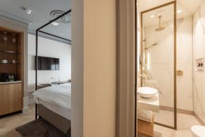a bathroom with a bed and a shower and a sink at Aparthotel Hattem in Hattem