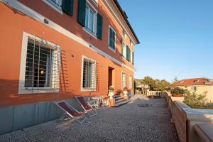 pomarańczowy budynek z krzesłami i stołami poza nim w obiekcie Trilocale in villa vista mare Apt 3 w mieście Varazze +22 zdjęcia