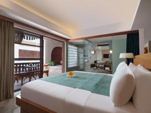 努沙杜瓦Amnaya Resort Nusa Dua的一间带一张白色大床的卧室和一间客厅