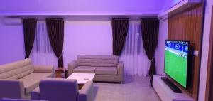 a living room with couches and a flat screen tv at Presken Hotels @ Victoria Island in Apese