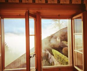 - une fenêtre avec vue sur la montagne dans l'établissement La Fleur de Lys, à Gruyères