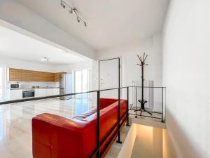 a red couch in a room with a kitchen at Panoramic Cityscape Maisonette in Agios Dimitrios in Athens +15 photos