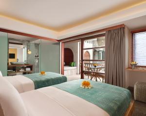努沙杜瓦Amnaya Resort Nusa Dua的有两张床和一个阳台的酒店房间