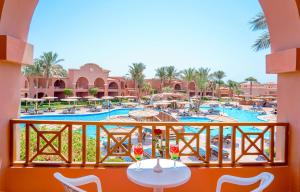 een balkon met uitzicht op het zwembad van een resort bij Charmillion Gardens Aquapark in Sharm El Sheikh