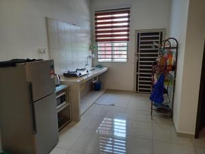 uma cozinha com um frigorífico de aço inoxidável e piso em azulejo em Homestay Zaki D'Gerik em Gerik
