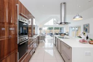 uma grande cozinha com armários de madeira e bancadas brancas em Luxurious & Spacious 3BR House with a Hot Tub em Kinross
