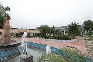a fountain in the middle of a courtyard with a statue at Tivoli Royal Palace in Janauli