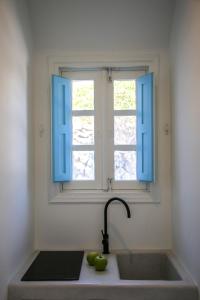 encimera de cocina con fregadero y ventana en SunSea Living Suites, en Vourvoúlos