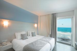 a bedroom with a bed with a view of the ocean at Rhodos Horizon Blu-Adults Only in Rhodes Town