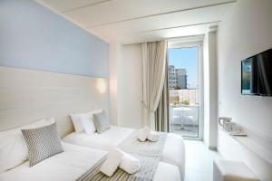 a white hotel room with a bed and a window at Rhodos Horizon Blu-Adults Only in Rhodes Town