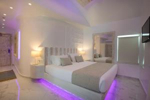 a white bedroom with a large bed with purple lights at Rhodos Horizon Blu-Adults Only in Rhodes Town