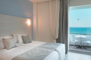 a hotel room with a bed and a view of the ocean at Rhodos Horizon Blu-Adults Only in Rhodes Town