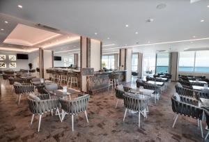 a restaurant with tables and chairs and a bar at Rhodos Horizon Blu-Adults Only in Rhodes Town