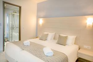 a bedroom with a large white bed with towels on it at Rhodos Horizon Blu-Adults Only in Rhodes Town