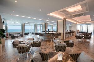 a restaurant with tables and chairs in a building at Rhodos Horizon Blu-Adults Only in Rhodes Town