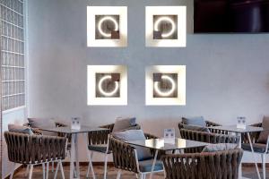 a dining room with tables and chairs and pictures on the wall at Rhodos Horizon Blu-Adults Only in Rhodes Town