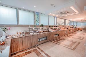 a large kitchen with a long counter with many sinks at Rhodos Horizon Blu-Adults Only in Rhodes Town