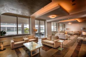 a living room with couches chairs and a table at Rhodos Horizon Blu-Adults Only in Rhodes Town