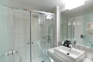 a white bathroom with a shower and a sink at Rhodos Horizon Blu-Adults Only in Rhodes Town