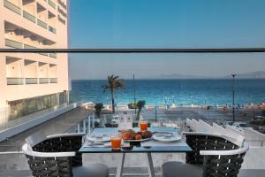 a table on a balcony with a view of the ocean at Rhodos Horizon Blu-Adults Only in Rhodes Town