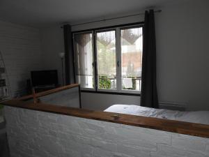 a bedroom with a bed and a large window at Studio très confortable in Limoges