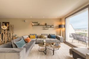 a living room with a couch and a large window at Annecy Lake, Luxury top floor apartment - LLA Selections by Location Lac Annecy in Annecy