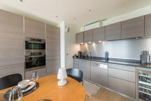 a kitchen with a wooden table with chairs and a dining room at Annecy Lake, Luxury top floor apartment - LLA Selections by Location Lac Annecy in Annecy