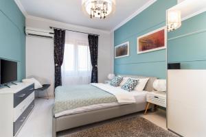 a bedroom with blue walls and a bed with a chandelier at Moonlight Central Apartments in Oradea