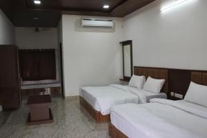 a hotel room with two beds and a window at Chitrakoot Garden and Resorts in Pushkar