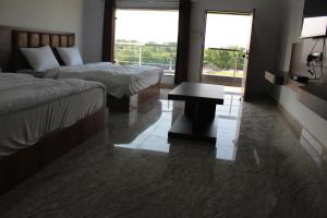 a hotel room with two beds and a table at Chitrakoot Garden and Resorts in Pushkar