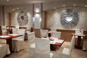 a restaurant with white chairs and tables and mirrors at Rhodos Horizon Blu-Adults Only in Rhodes Town