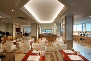a restaurant with white chairs and tables in a room at Rhodos Horizon Blu-Adults Only in Rhodes Town