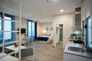 a kitchen and living room with a bed in a room at EM21 Apartamentos in Córdoba