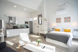 a white bedroom with a bed and a kitchen at EM21 Apartamentos in Córdoba
