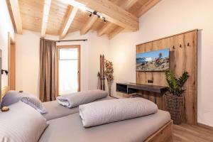 two beds in a room with wooden ceilings at Landhaus Sonnenwiese in Sölden