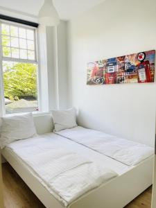 Cama blanca en habitación con ventana en aday - Aalborg mansion - Big apartment with garden, en Aalborg