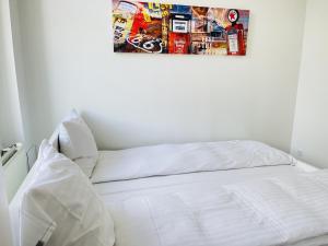 1 cama con sábanas blancas y una foto en la pared en aday - Aalborg mansion - Big apartment with garden en Aalborg
