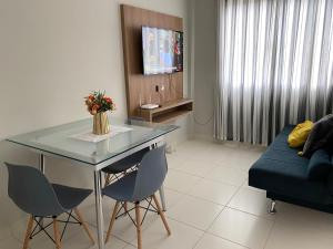 a living room with a table and chairs and a couch at Hotel APART Zuccolotto 301 in Aracruz
