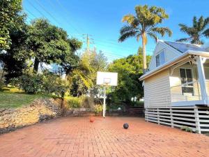a house with a basketball hoop on a brick driveway at Quiet, cozy and calm 3 bedroom house. in North Tamborine