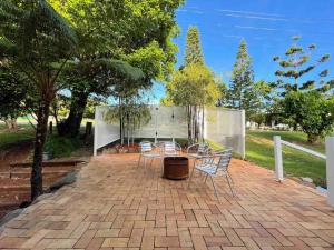 a patio with a table and chairs and trees at Quiet, cozy and calm 3 bedroom house. in North Tamborine