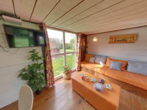 a living room with a couch and a window at Holiday village in Réclinghem