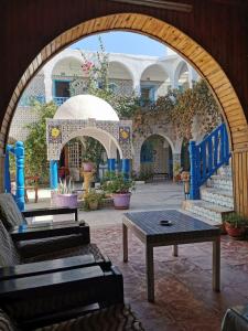 an outdoor area with benches, tables, and umbrellas at Hôtel Sindbad in Houmt Souk