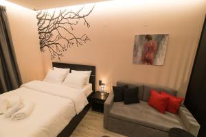 sypialnia z dwoma łóżkami i kanapą w obiekcie Elegant Studio w mieście Janina