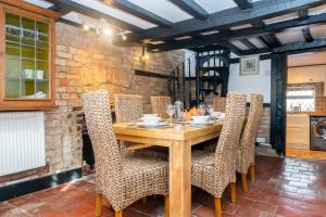 a dining room with a wooden table and chairs at 3 Bed Cottage-Parking-Garden-Free Hot Tub Weekends in Gloucester