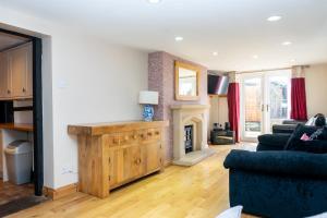 a living room with a couch and a fireplace at 3 Bed Cottage-Parking-Garden-Free Hot Tub Weekends in Gloucester