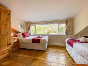 a bedroom with two beds and a window at 3 Bed Cottage-Parking-Garden-Free Hot Tub Weekends in Gloucester