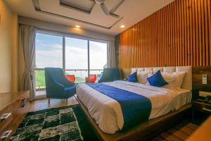a bedroom with a large bed and a large window at Hotel Shivaay in Dharamshala