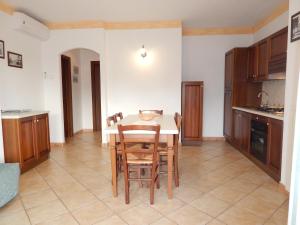Residenza Sarra di Entu في كانيجيوني: مطبخ مع طاولة وكراسي في غرفة