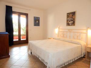 ein Schlafzimmer mit einem Bett und eine Tür mit einem Fenster in der Unterkunft Residenza Sarra di Entu in Cannigione
