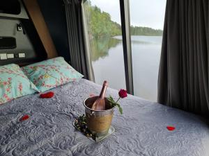 a bed with a bottle and a flower on it at Neljän Tuulen Tupa in Kaamanen